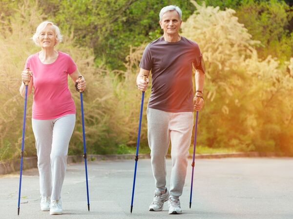 Eine Frau und ein Mann beim Nordic Walking