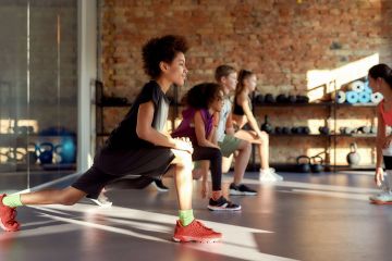 Portrait of a boy smiling while warming up, exercising together with other kids