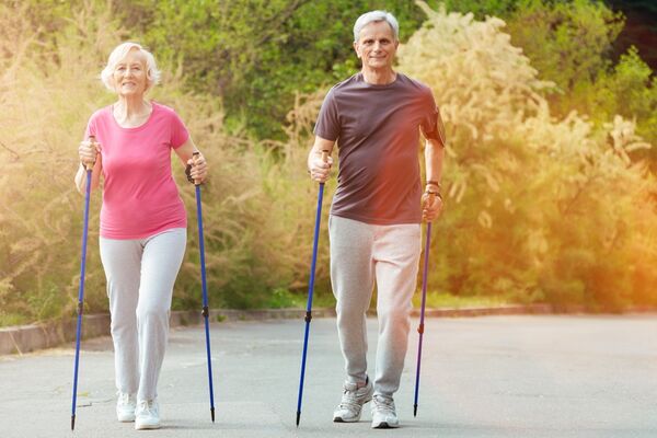 Eine Frau und ein Mann beim Nordic Walking